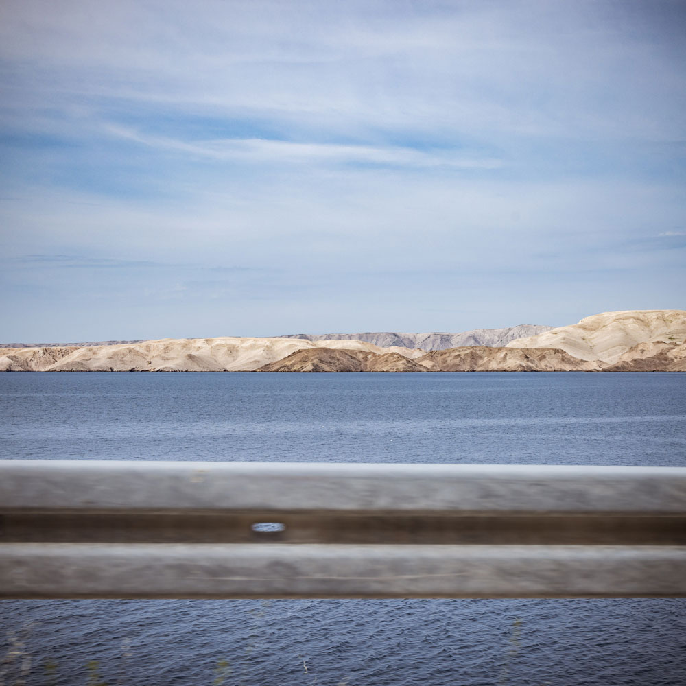 küstenstraße, blick über leitplanke auf karge insel